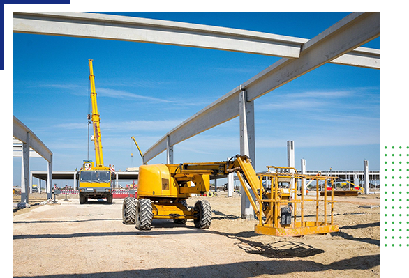 A yellow crane is in the foreground while another construction vehicle is behind it.