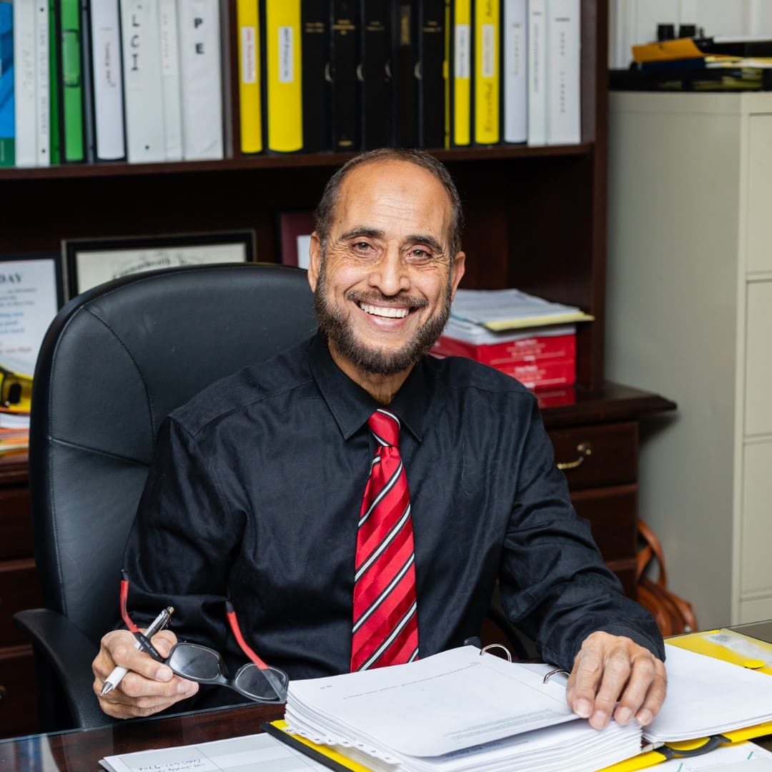 A man sitting at his desk in front of papers.